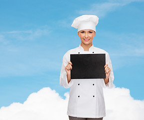 Image showing smiling female chef with black blank paper