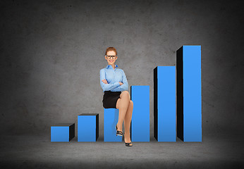 Image showing smiling businesswoman in glasses sitting on chart