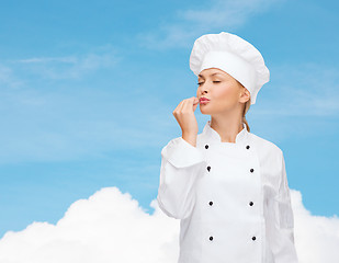 Image showing smiling female chef showing delicious sign