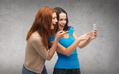 Image showing two smiling teenagers with smartphone