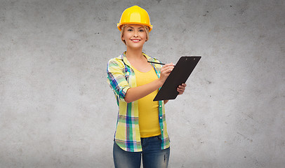 Image showing smiling woman in helmet with clipboard