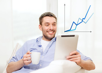 Image showing smiling man working with tablet pc at home