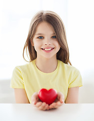 Image showing smiling little girl with red heart at home