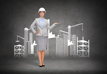 Image showing businesswoman in helmet showing construction site