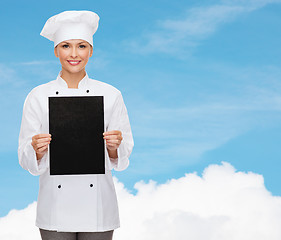 Image showing smiling female chef with black blank paper