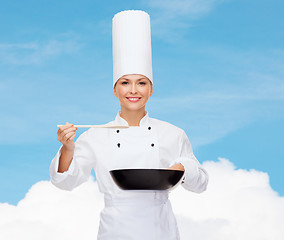 Image showing smiling female chef with pan and spoon