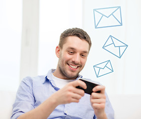 Image showing smiling man with smartphone at home