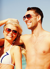 Image showing happy couple in sunglasses on the beach