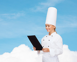 Image showing smiling female chef with black blank paper