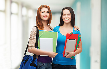 Image showing two smiling students with bag, folders and tablet