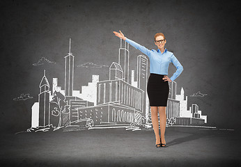 Image showing smiling businesswoman in glasses pointing her hand