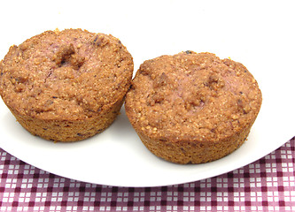 Image showing Two raspberry muffins on a white plate of chinaware