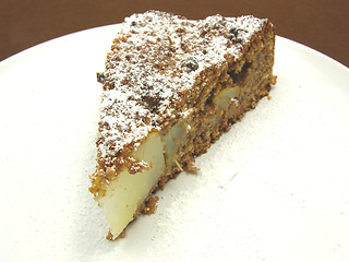 Image showing One slice of pear cake on a white plate dusted with powder sugar