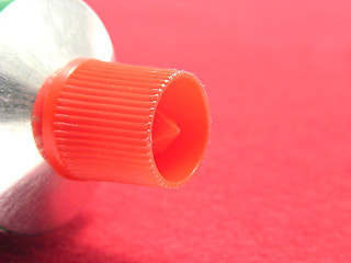 Image showing A lying tube with a red sealing on red underground