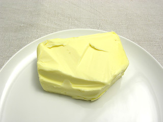 Image showing Butter placed on a round plate arranged on a placemat