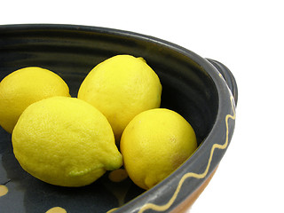 Image showing Four yellow citrus fruits in a blue pottery