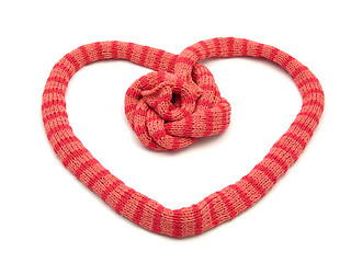 Image showing Red striped knitting scarf arranged as heart on white