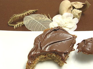 Image showing Bitten into a wholemeal bread with hazelnut spread on a plate wi