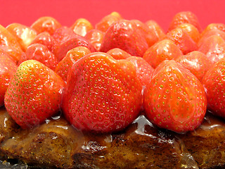 Image showing Lateral close-up view of a strawberry cake on red background