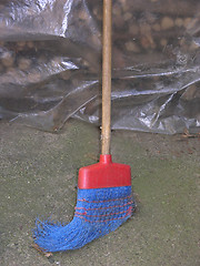 Image showing Old and nagged blue plastik broom with wooden stick