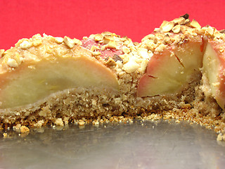 Image showing Cutted  wholemeal apple cake  on a cake tray on red background