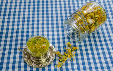 Image showing healing marigold tea and jar dried flower on table 