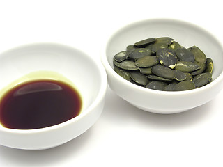 Image showing Two bowls of chinaware with pumpkin seeds and pumpkin seed oil