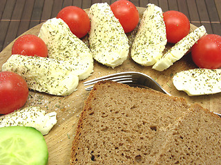 Image showing Sliced mozzarella with little tomatoes, a slice of cucumber and