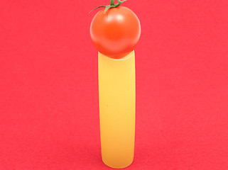 Image showing One unboiled canneloni with one tomato on red felt