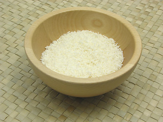 Image showing Wooden bowl with coconut flakes on rattan underlay