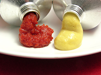 Image showing Two open tubes with tomato puree and mustard