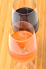 Image showing Glasses of Red and Pink Wine on Wooden Table