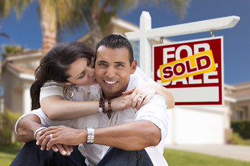 Image showing Hispanic Couple, New Home and Sold Real Estate Sign