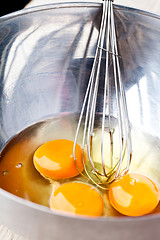 Image showing whisking eggs in metal bowl 