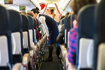 Image showing Interior of airplane with passengers on seats.