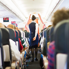 Image showing Interior of airplane with passengers on seats.