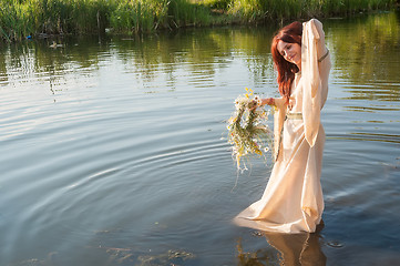Image showing Beautiful red-haired girl relaxes in water