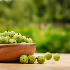 Image showing Close-Up Of Gooseberries In Vintage Wooden Bowl On Wooden Table