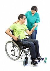 Image showing Physical therapist works with patient in lifting hands weights. 