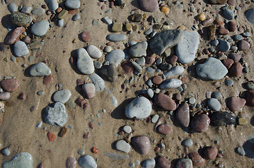 Image showing Detail of a wet sandy beach with smooth pebbles