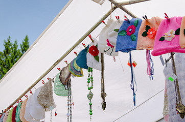 Image showing colored baby caps hang on rope village fair 