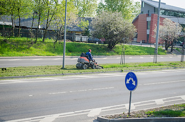 Image showing worker with grass cutting machine street pavement 