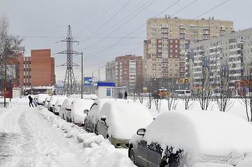 Image showing The cars brought by snow stand on a road roadside.