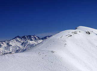 Image showing Snowboarders and skiers downhill on off piste slope