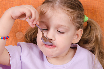 Image showing Funny baby eats with a spoon