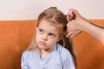 Image showing Mom upset girl hair braids