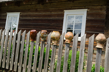 Image showing rural fence with old cracked earthen jars outdoor 