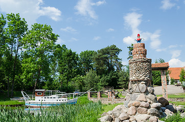 Image showing stylized stone lighthouse and small tourist boat  