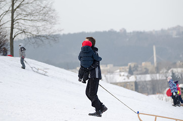 Image showing father with son climb up snowy hill in winter time 