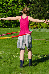 Image showing woman turn spin hula hoop ring on waist in garden 